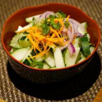 Cucumber Salad · Sliced cucumber, red onions dressed in a sweet sour vinaigrette which is served as a salad b...