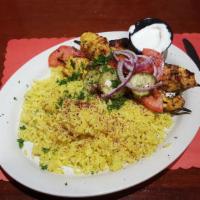 Shish Tawook · Tangy marinated chicken breast cubes char-broiled and served with garlic sauce and rice.