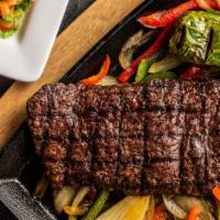 Parrilla · Tender and juicy skirt steak served over fajita peppers, with sides of pico de gallo, sour c...