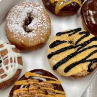 Signature Six · Enjoy this box of Signature donuts! Each box contains:
Katy's Cinnamon Roll,
Peanut Butter C...