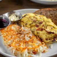 Midwestern Omelette · Ham off the bone, bacon and Wisconsin sharp cheddar with a side of hash browns, toast, butte...