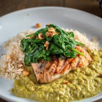 Atlantic Salmon · Wild salmon fillet, coconut curry, roasted garlic, and spinach with hazelnuts on top.