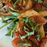 Bruschetta · Crostini topped with fresh grape tomatoes, pesto & basil