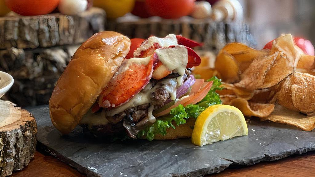 Lobster Burger · Our spin on surf 'n' turf a 1/2 lb angus steak burger topped with hot lobster aioli lettuce tomato and onion all stacked up on a brioche bun.