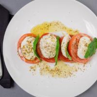 Caprese Salad · Beefsteak tomatoes, fresh mozzarella, basil, extra virgin olive oil.