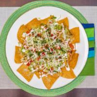 Nachos · Corn tortilla chips topped with cheddar cheese, tomato, lettuce, sour cream and jalapeños.