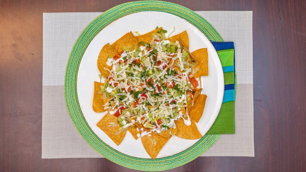 Nachos · Corn tortilla chips topped with cheddar cheese, tomato, lettuce, sour cream and jalapeños.