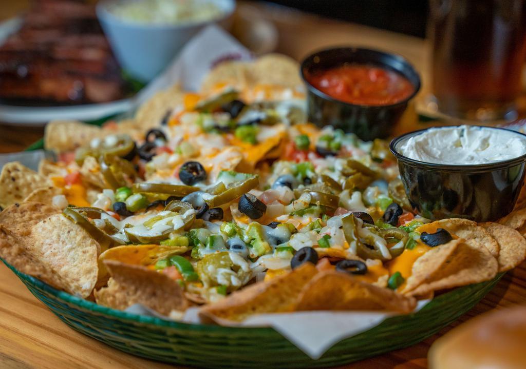 Loaded Lizard Nachos & Cheese · Nachos covered with cheddar, mozzarella cheese, tomatoes, onions, black olives, green peppers, and jalapeños. You can make it with plain chips with cheddar cheese sauce and a side of salsa or with chicken for additional charges.