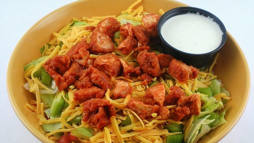 Buffalo Chicken Salad · Spicy. Crispy chicken tenders tossed in our hot sauce, cheddar cheese, diced tomatoes, and celery. Served on top of fresh mixed greens. Served with blue cheese dressing.