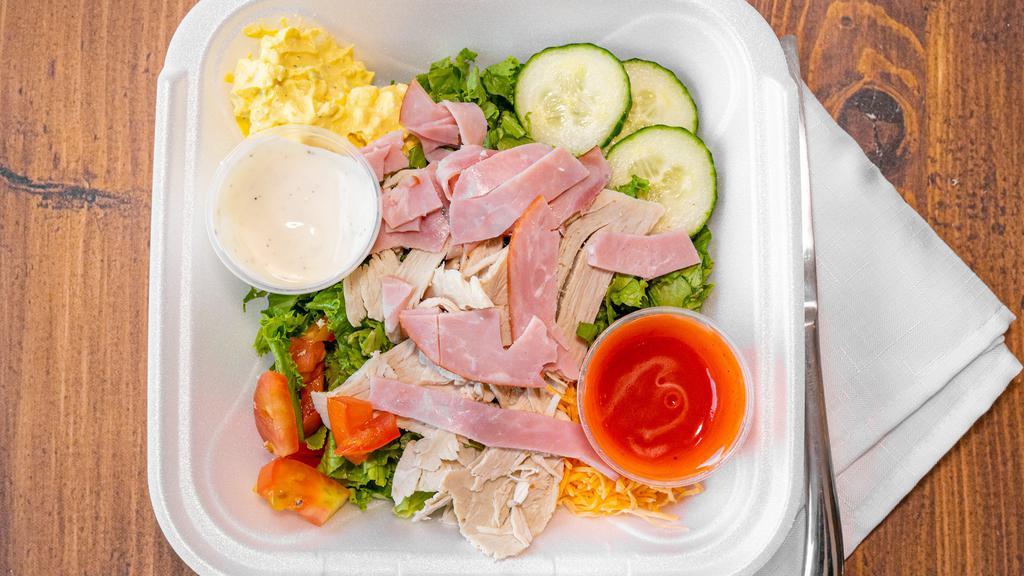 Chef Salad · Chopped lettuce, turkey, ham, shredded cheese, tomatoes, and scoop of egg salad.