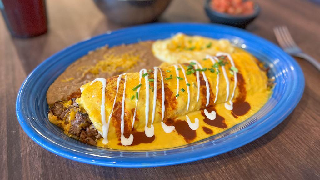 Fajita Steak Burrito · Grilled Fajita Steak, sauteed peppers and onions, rice, and Chili con Queso wrapped up in a large flour tortilla and topped with both Red & Cheese Enchilada sauce and a dollop of sour cream. Served with your choice of two sides.