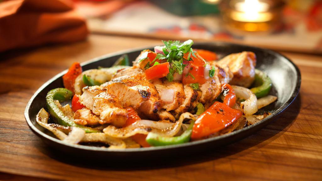 Chicken Fajitas · Grilled Chicken served sizzling with onions, green peppers, warm flour tortillas, cheese, lettuce, sour cream and Pico de Gallo.