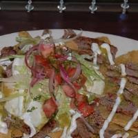Chilaquiles · Tortilla Chips sauteed in a green sauce, topped with two eggs any style, asada/steak or  chi...