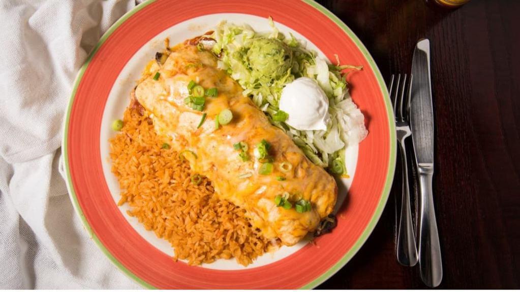 Fajita Burrito · A flour tortilla filled with sauteed onions, green peppers, pico de gallo, mixed cheese, and your choice of grilled steak or chicken. Topped with red chili sauce, mixed cheese, and green onions. Served with a scoop of sour cream.
