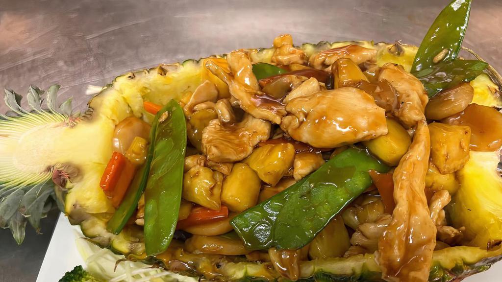 Pineapple Chicken · Sliced chicken with sugar snap peas, carrots, water chestnuts, and fresh pineapple chunks served in a fresh pineapple bowl.