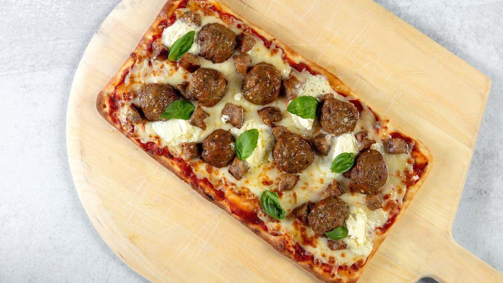 Italian Meat-Lovers Flatbread · Stone-fired flatbread with a rich Marinara sauce base, topped with mozzarella cheese, meatballs, mild Italian sausage, ricotta and fresh basil.