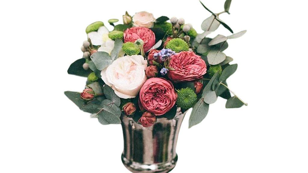 Never Let Go · This gorgeous, vibrant arrangement is created with red roses and lavender waxflower with lush greens in a vibrant red cube vase. This beautiful arrangement is the perfect way to show your love