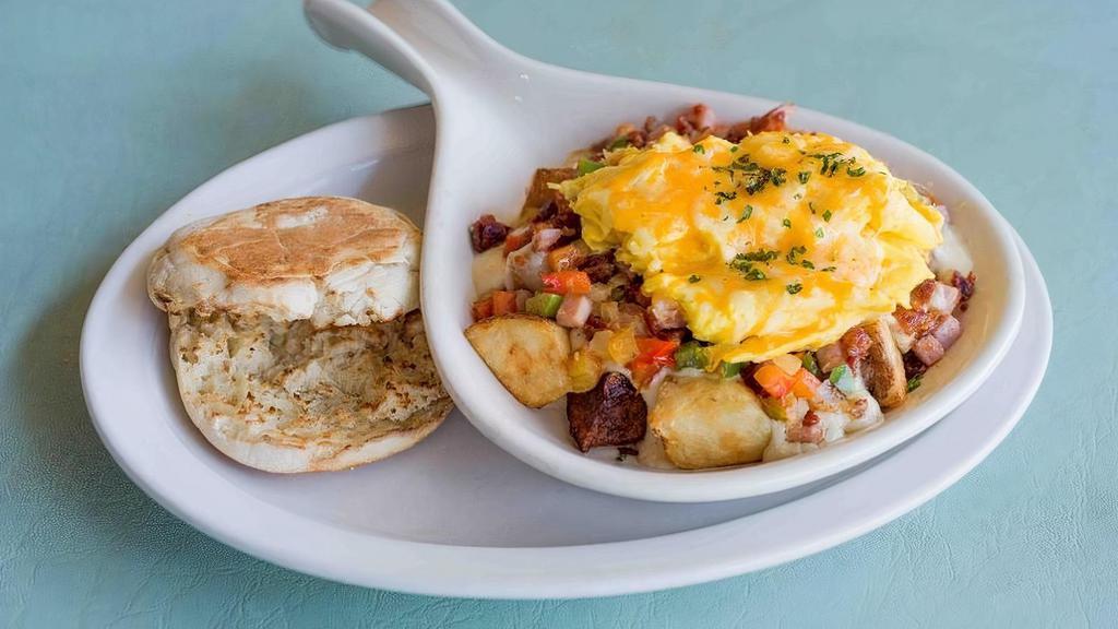 The Carolina · A southern casserole of goodness combining home fries, bell pepper, onion, diced ham, crumbled bacon, cheddar cheese, Monterey Jack cheese, white bacon gravy, and topped with two eggs your sway. Served with your choice of bread or fresh muffin.