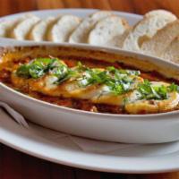 Baked Goat Cheese · Sliced goat cheese baked in a spicy Arrabbiata sauce with fresh basil. Served with toasted c...