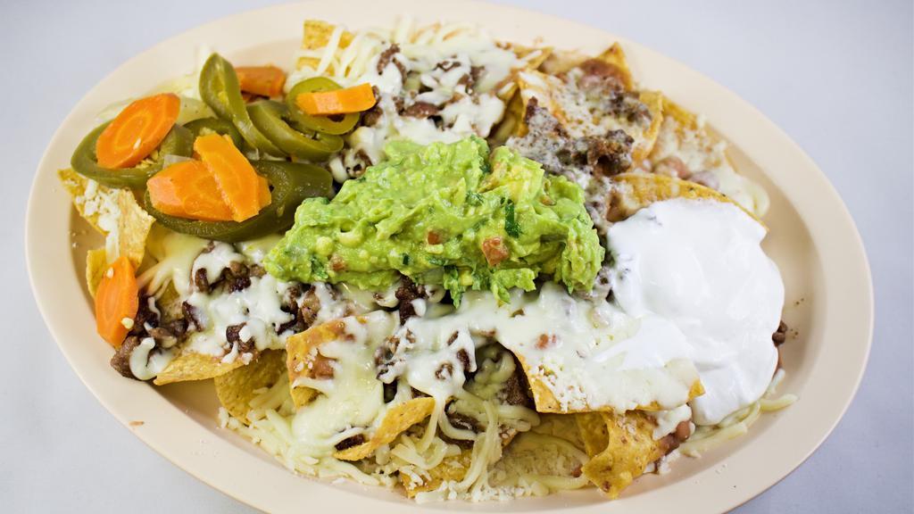 Super Nachos · Choice of meat with beans, cheese, sour cream, guacamole and jalapenos.