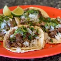 Lamb Taco (Barbacoa) · Delicious lamb taco served on two corn tortillas topped with onions and cilantro.