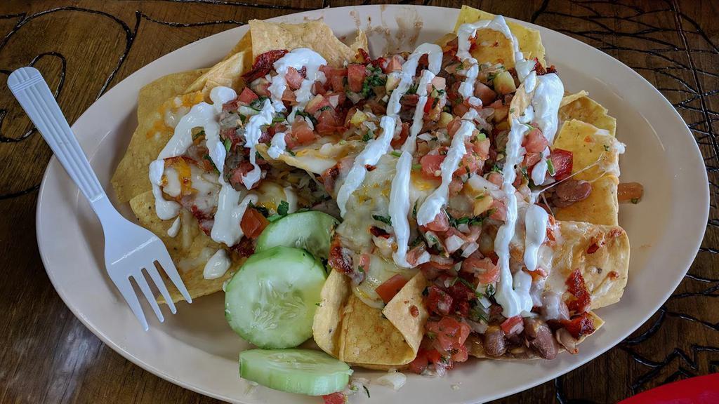 Nachos · Crisp nachos topped with melted mozzarella cheese and served with pico de gallo and sour cream.