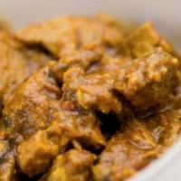 Goat Curry · Boneless tender well seasoned goat cooked in a spiced tomato sauce with onion and freshly mi...