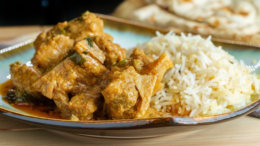 Goat Korma · Tender pieces of richly seasoned goat cooked in a creamy sauce hinted with spices, cashew nuts and raisins.