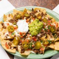 Nachos El Pueblito · Served with beans, cheese, meat, lettuce, tomato, sour cream, and avocado.