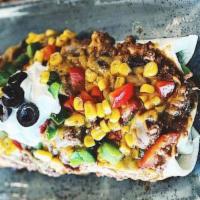 Texas Burrito · Ground beef, slow cooked chili, cheese, black olives, bell peppers, roasted corn, sour cream.