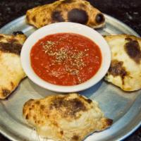 Mini Calzones · Vegetarian. Half-moon pockets of dough are filled with mozzarella and ricotta cheese, baked ...