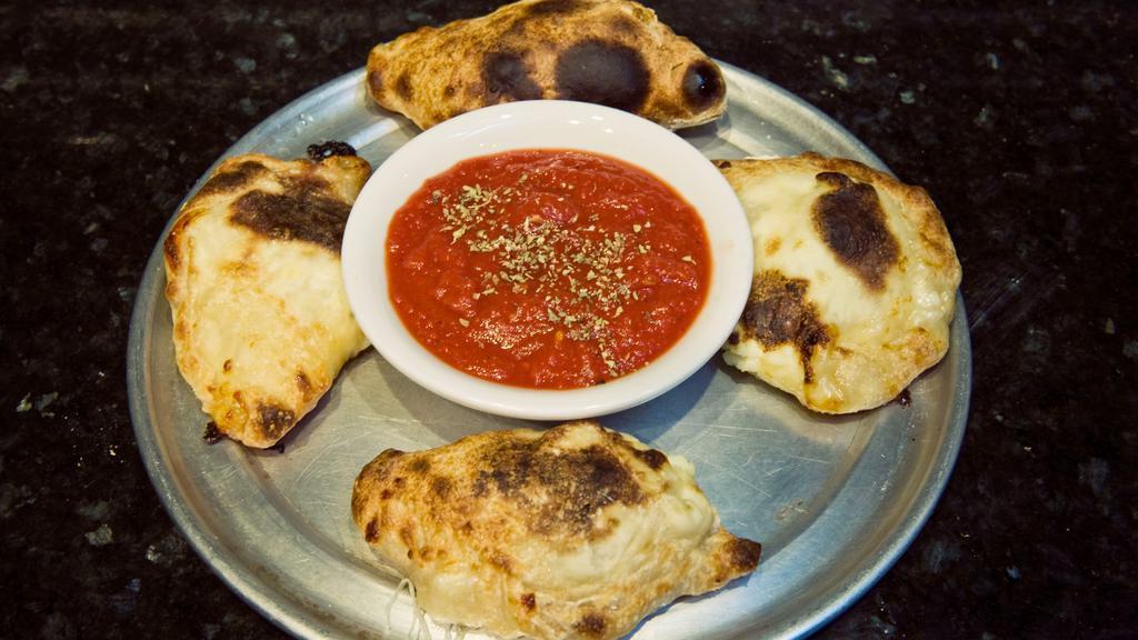 Mini Calzones · Vegetarian. Half-moon pockets of dough are filled with mozzarella and ricotta cheese, baked in our brick oven. Served with a side of marinara.