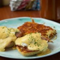 Eggs Benedict · English muffin topped with ham, poached egg, and hollandaise sauce. Served with hash browns.