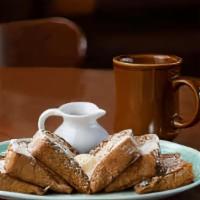 Classic French Toast · Three grilled slices of egg battered French toast topped with powdered sugar.