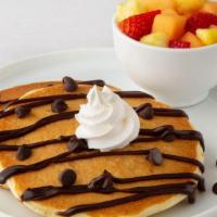Kid'S Chocolate Chip Pancakes · Two chocolate chip pancakes drizzled with chocolate sauce and topped with whipped cream.