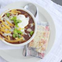 Texas Beef Chili · A bean-less Texas-style favorite. Topped with sour cream, green onions and cheddar cheese.