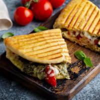Panini With Ham And Pesto · Hot off the press panini with fresh ham, delicious pesto, melty cheese, and sprouts.