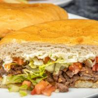 Steak Torta (Asada) · Mexican sandwich served with beans, cheese, lettuce, tomato, and sour cream.