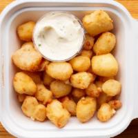 Cheese Curds · Pile of white cheddar cheese curds, breaded and deep fried, served with garlic-herb sauce (v)