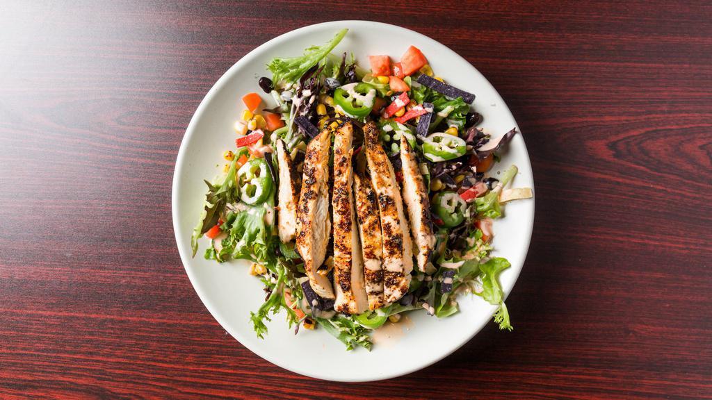 Southwest Chicken Salad · Mixed greens, black beans, smoked corn, jalapeños, tomato, and tortilla strips. Topped with blackened grilled chicken and served with a spicy ranch dressing.