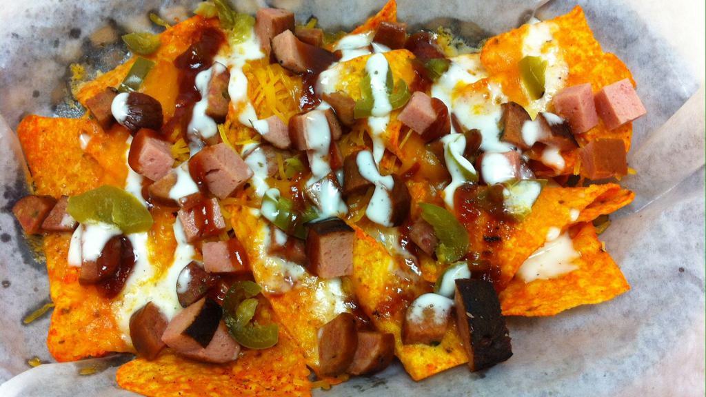Bbq Nachos · Smoked hot link & bologna, cheddar cheese, layered on a bed of doritos, topped with jalapeno & onions and drizzled with bbq sauce & ranch dressing.