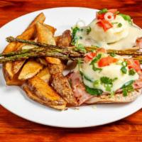 Eggs Benedict · Poached eggs, ham, English muffin, and hollandaise sauce with side of potatoes.