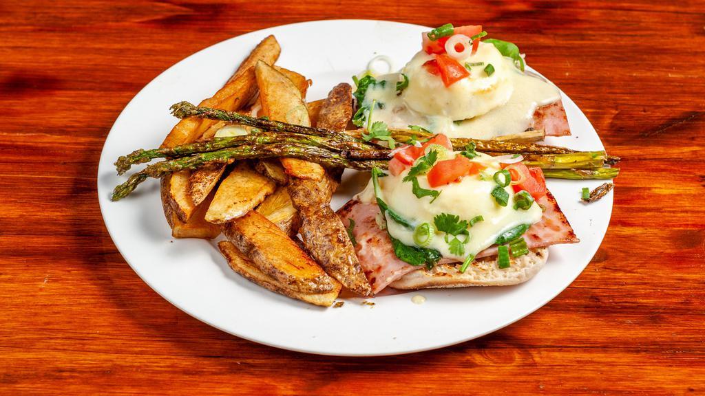 Eggs Benedict · Poached eggs, ham, English muffin, and hollandaise sauce with side of potatoes.