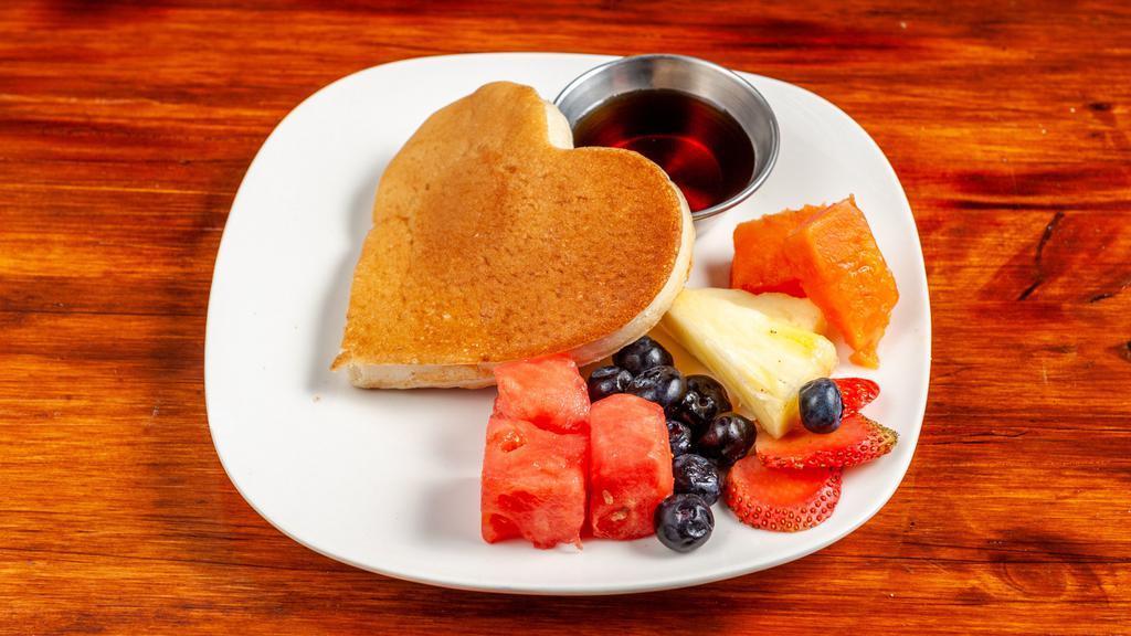 Pancakes With Fruit · Two pancakes topped with seasonal fruit and powdered sugar with honey or jelly.
