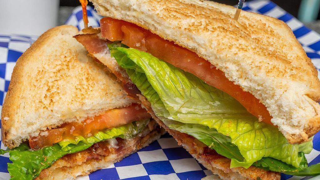 Blt · Strips of crispy bacon, lettuce, tomatoes, and mayo on toasted on white bread.