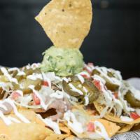 Super Nachos · Tortilla chips topped with choice of meat, beans, cheddar cheese, onion, tomato, guacamole, ...