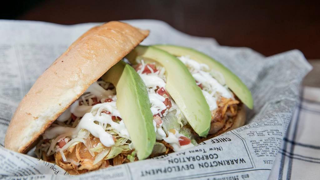 Torta · A Mexican sandwich with choice of meat, refried beans, lettuce, tomatoes, sour cream, cheese, and avocado.