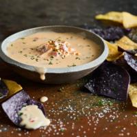 Cheddar Queso And Chips · Melted cheddar, roasted peppers, and queso dip. Served with tortilla chips.