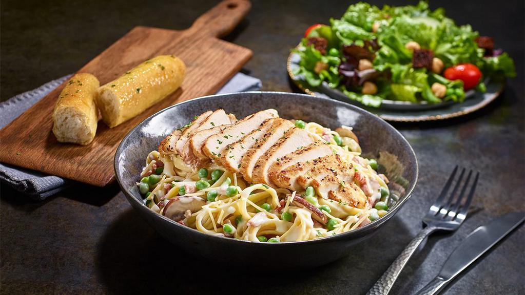 New Chicken Carbonara · Grilled chicken served atop fettuccine tossed with alfredo sauce, bacon, peas, roasted baby bellas, and Parmesan cheese.
