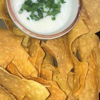 Chips & Queso Poblano · White melted Monterey cheese with roasted peppers topped with cilantro.